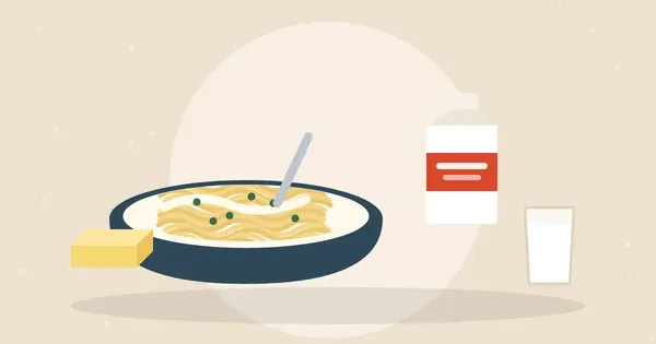Bowl of creamy fettuccine with parsley next to a cream carton, butter and a glass of milk